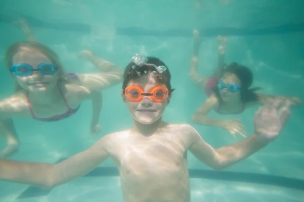 Bonito crianças posando debaixo d 'água na piscina — Fotografia de Stock