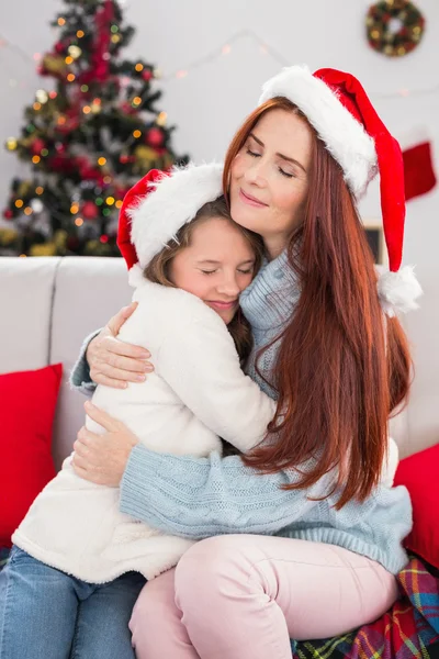 Festive madre e figlia che si abbracciano sul divano — Foto Stock