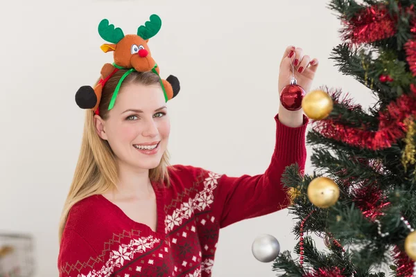 Vrouw opknoping kerstversiering op boom — Stockfoto