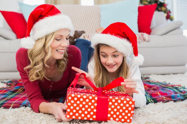 Feestelijke meisje openen een geschenk met moeder — Stockfoto