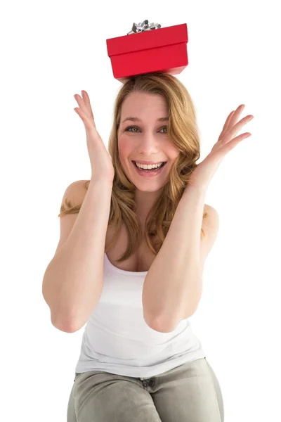 Smiling woman balancing christmas gift on her head — Stock Photo, Image