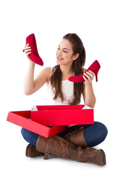 Content brunette holding red shoes — Stock Photo, Image