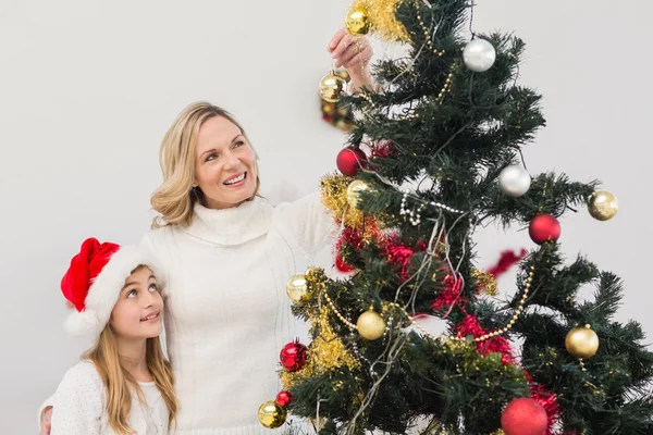 Feestelijke moeder en dochter kerstboom versieren — Stockfoto