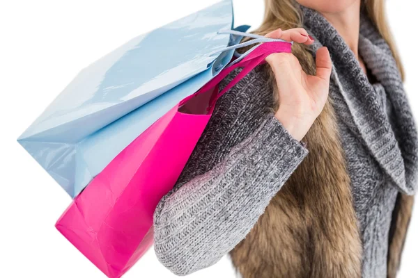 Loira em roupas de inverno segurando sacos de compras — Fotografia de Stock