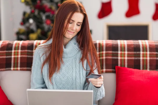 Festive redhead shopping online on couch — Stock Photo, Image