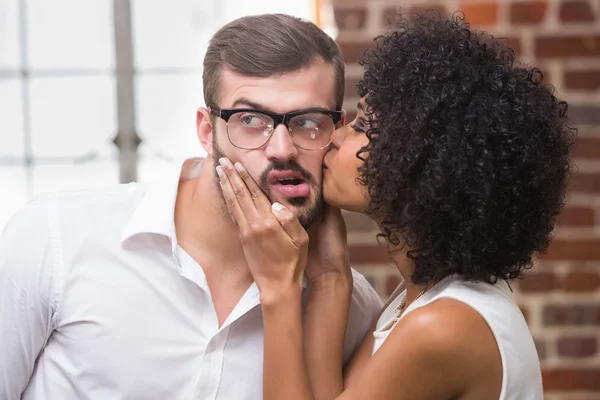 Woman kissing man in office — Stock Photo, Image