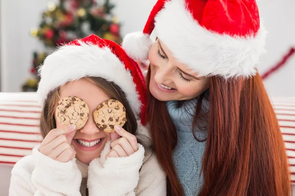 节日的母亲和女儿在沙发上用饼干 — 图库照片