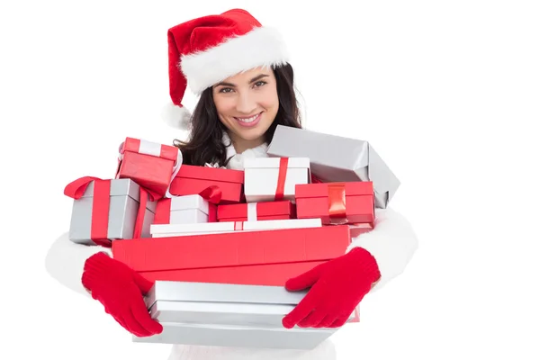 Smiling brunette in santa hat holding stack of presents — Stock Photo, Image