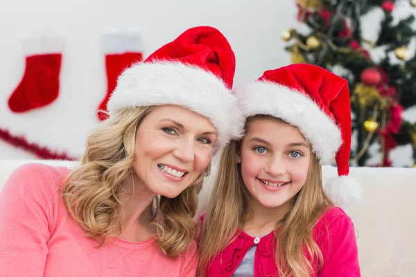 Festive mother and daughter smiling at camera — Stock Photo, Image