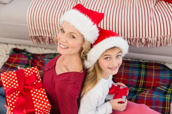 Festliche Mutter und Tochter lächeln mit Geschenken in die Kamera — Stockfoto