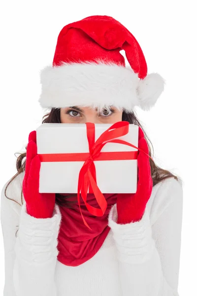 Morena en guantes rojos y sombrero de santa mostrando regalo — Foto de Stock