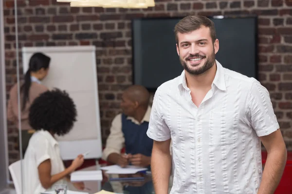 Jovem empresário sorridente com colegas — Fotografia de Stock