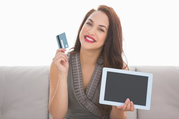 Hübsche Brünette zeigt Kreditkarte und Bildschirm von Laptop — Stockfoto