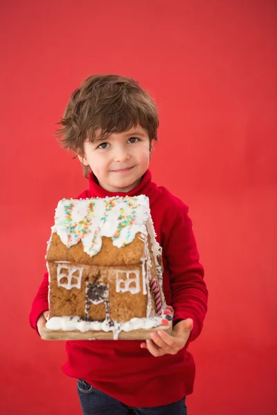 Niño festivo sosteniendo casa de jengibre — Foto de Stock