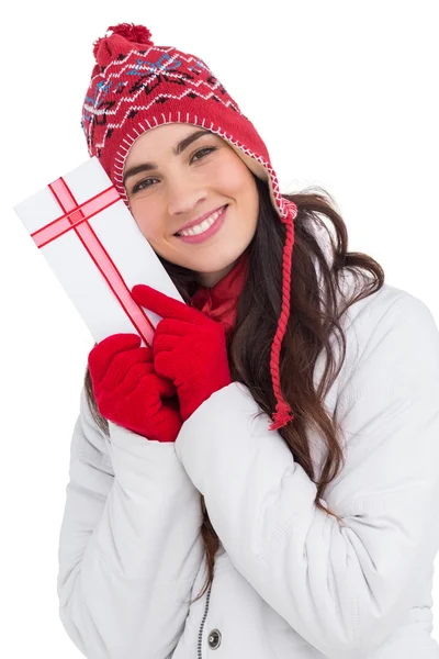 Праздничная брюнетка в зимней одежде, указывающая на подарок — стоковое фото