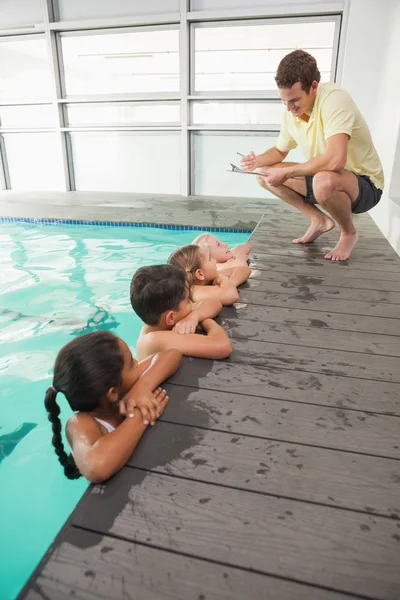 Graziosa classe di nuoto ascoltando allenatore — Foto Stock