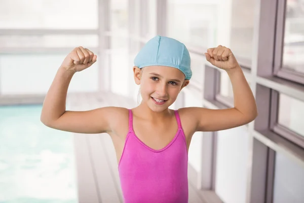Cute little girl flexing her arms — Stock Photo, Image