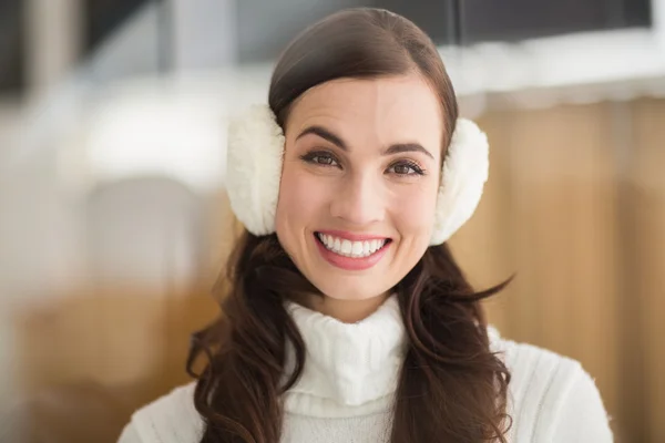 Schoonheid brunette met oorwarmers glimlachen op camera — Stockfoto