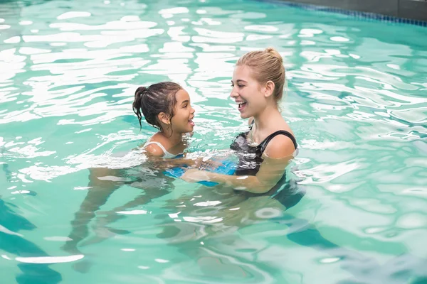 Cute little girl learning to swim with coach — Stock Photo, Image