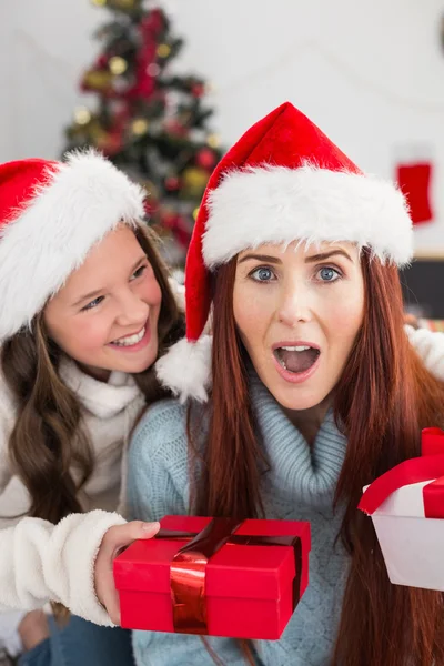 Festive mother and daughter exchanging gifts — Stock Photo, Image