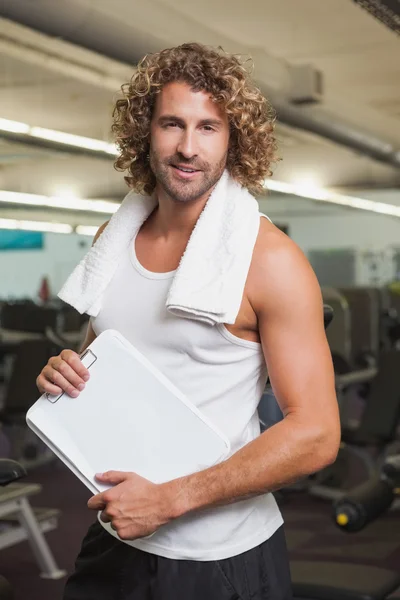 Knappe trainer met Klembord in gym — Stockfoto
