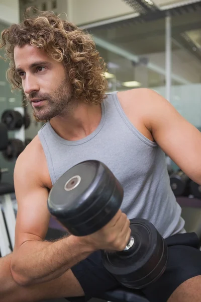 Hombre haciendo ejercicio con la mancuerna en el gimnasio — Foto de Stock