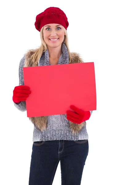 Rubia en ropa de invierno sosteniendo signo rojo — Foto de Stock