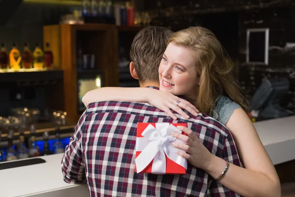 Young couple hugging with a gift — Stock Photo, Image