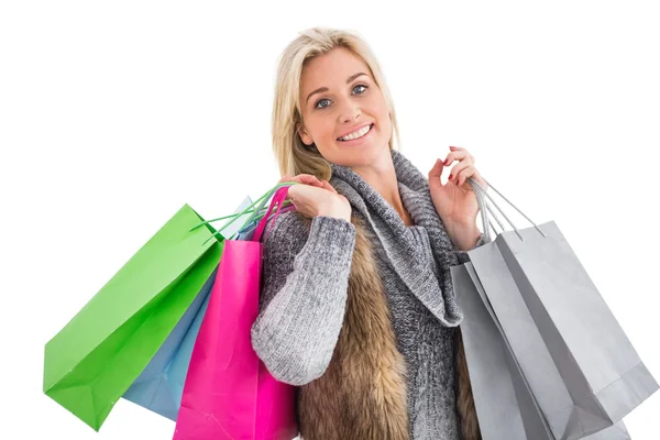 Blonde in winter clothes holding shopping bags — Stock Photo, Image
