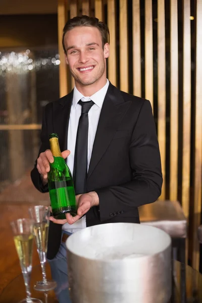 Hombre guapo mostrando botella de champán —  Fotos de Stock