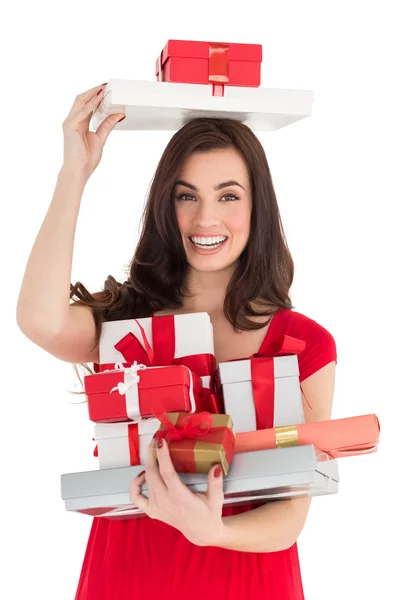 Smiling brunette holding many gifts — Stock Photo, Image