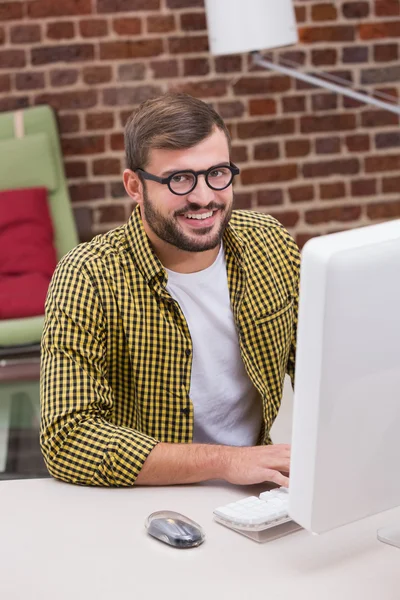 Sorridente casuale giovane uomo utilizzando il computer — Foto Stock