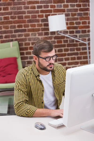 Serious casual young man using computer — Stock Photo, Image