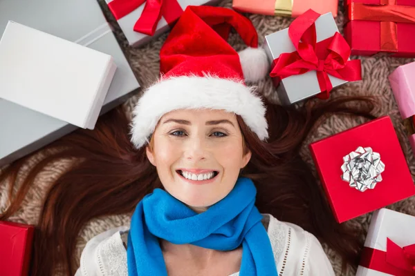 Pelirroja festiva sonriendo a la cámara con regalos — Foto de Stock