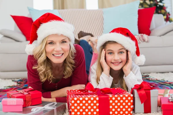 Festlig liten flicka med moder omgiven av gåvor — Stockfoto