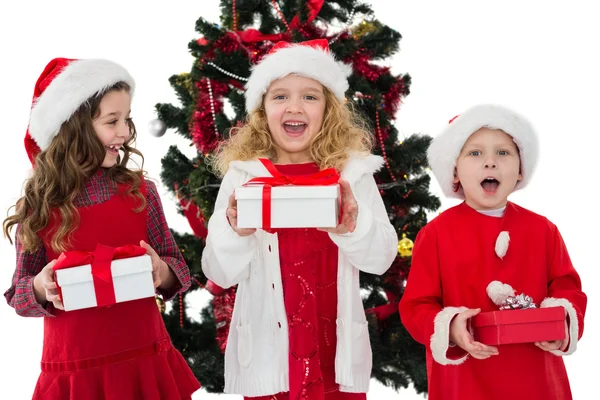 Hermanitos festivos sosteniendo regalos —  Fotos de Stock