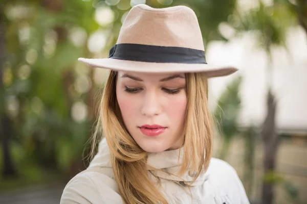 Mulher loira bonita com chapéu posando enquanto olha para baixo — Fotografia de Stock