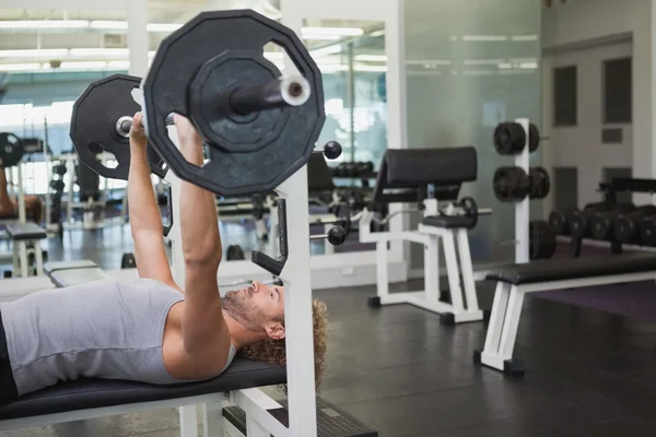 Uomo che solleva il bilanciere in palestra — Foto Stock