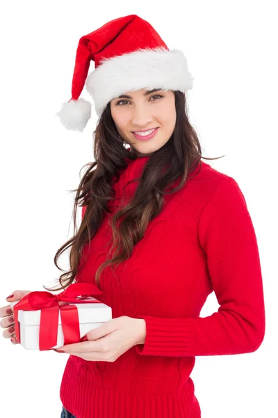 Sonriente morena en santa hat sosteniendo un regalo —  Fotos de Stock