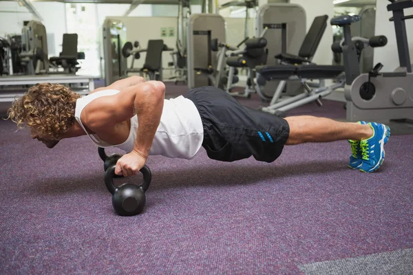 Člověk dělá push ups s konvicí zvony — Stock fotografie