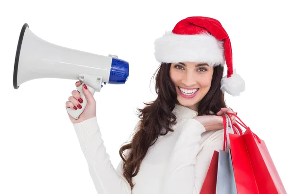 Lachende brunette holding geschenk zakken en megafoon — Stockfoto