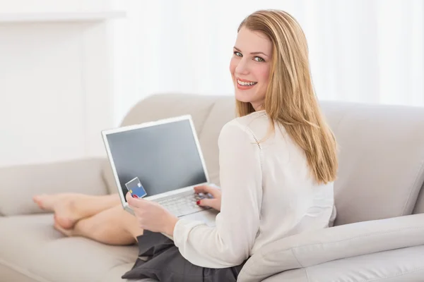 Vackra blonda tittar över axeln medan shopping online — Stockfoto