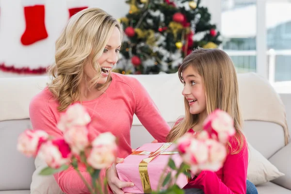 Liten flicka att ge mamman en julklapp — Stockfoto