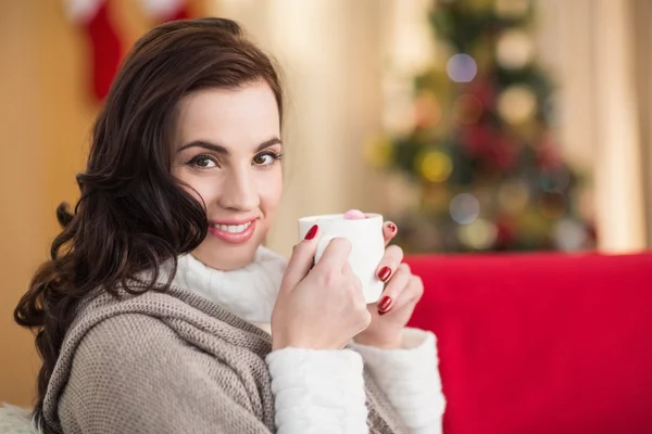 Morena sorridente segurando uma caneca de chocolate quente no Natal — Fotografia de Stock