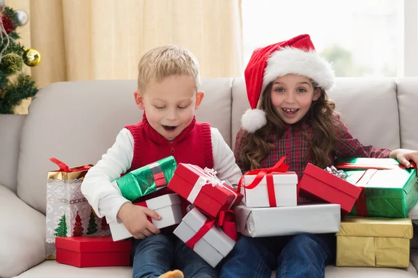 Frères et sœurs festifs entourés de cadeaux — Photo