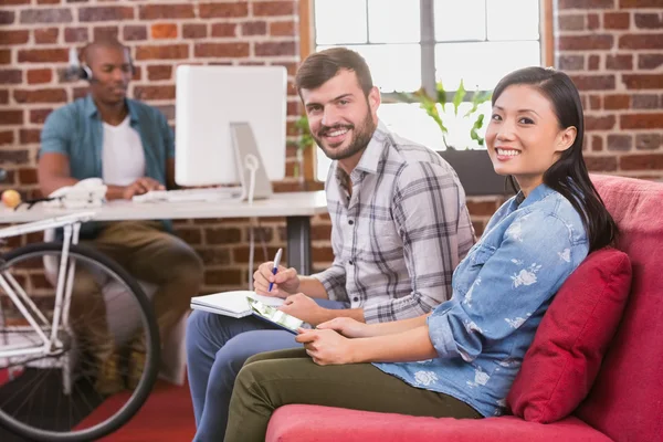 Colleagues using digital tablet on couch — Stock Photo, Image