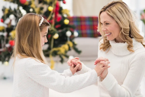 Feestelijke moeder en dochter naast kerstboom — Stockfoto