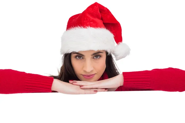 Pretty brunette in santa hat smiling at camera — Stock Photo, Image