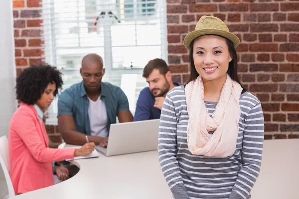 Woman with colleagues behind in office — Stock Photo, Image