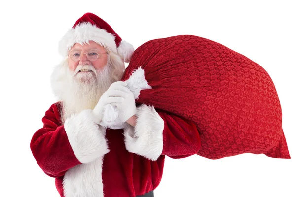 Papai Noel carrega seu saco vermelho e sorrisos — Fotografia de Stock